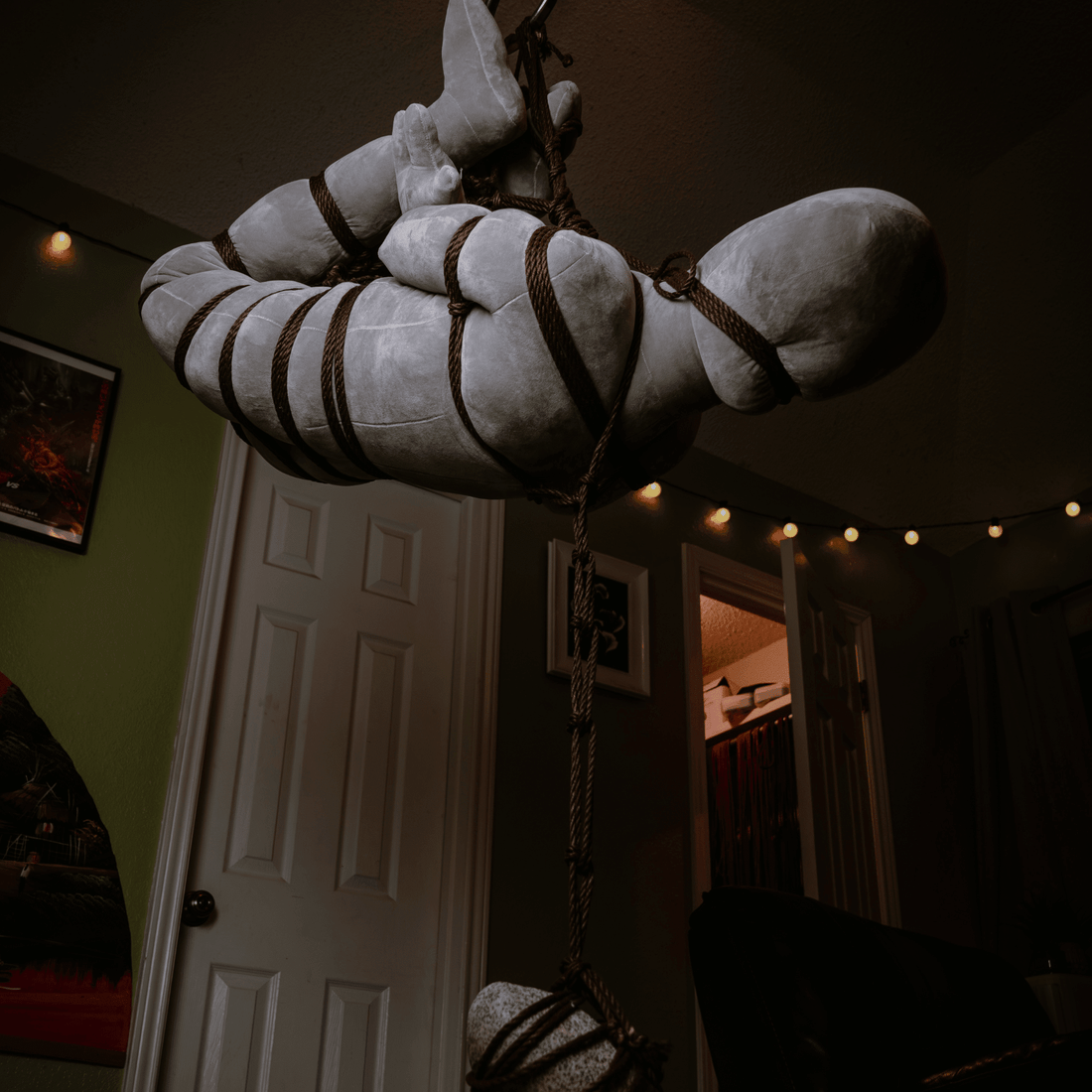 Shibari practice doll in a rope suspension