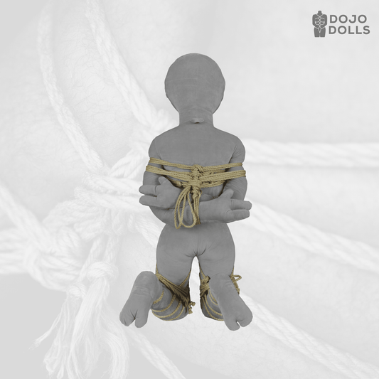 Kneeling shibari practice doll with bound wrists